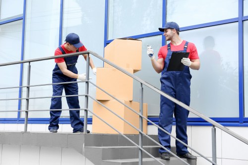 Professional movers handling furniture and boxes during an Ilford home move